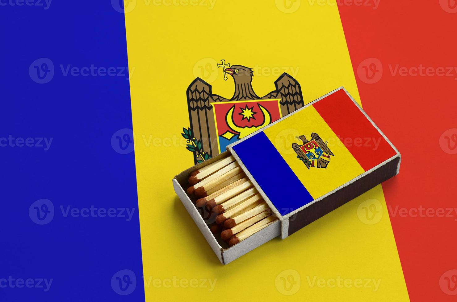 Moldova flag is shown in an open matchbox, which is filled with matches and lies on a large flag photo