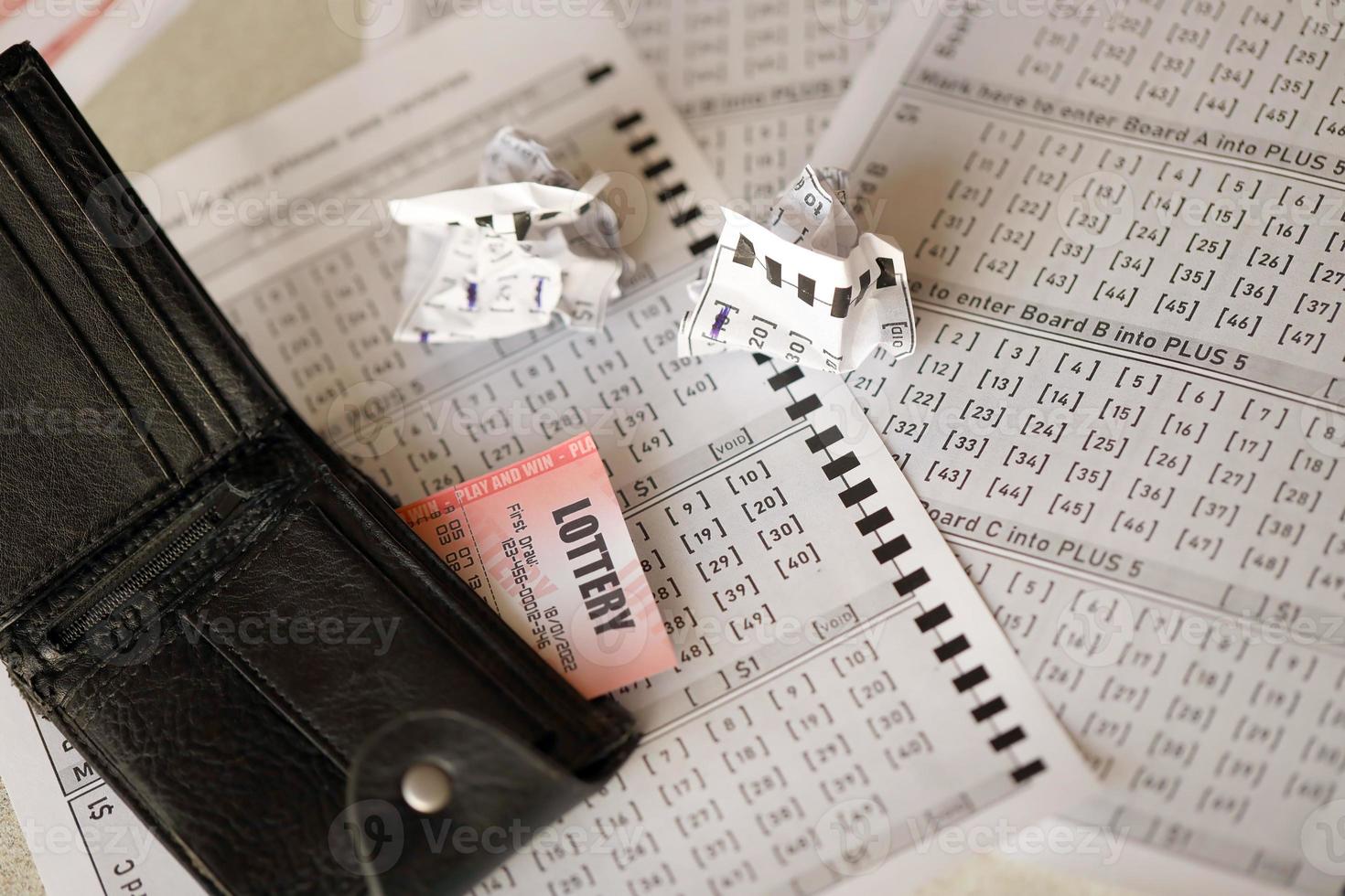 Crumpled lottery tickets and empty purse as symbol of losing the lottery game. Unlucky gambling results. Misfortune photo