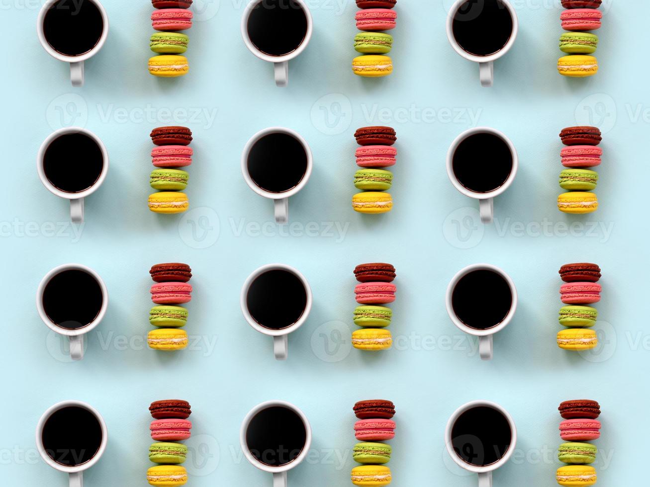 A pattern of many colorful dessert cake macaroon and coffee cups on trendy pastel blue background top view. Flat lay composition photo