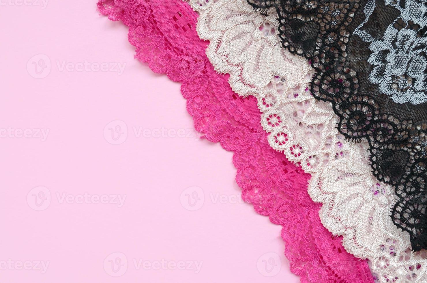 White, black and pink women underwear with lace on pink background with copy space. Advertising for shop of beautiful and comfortable women underwear photo