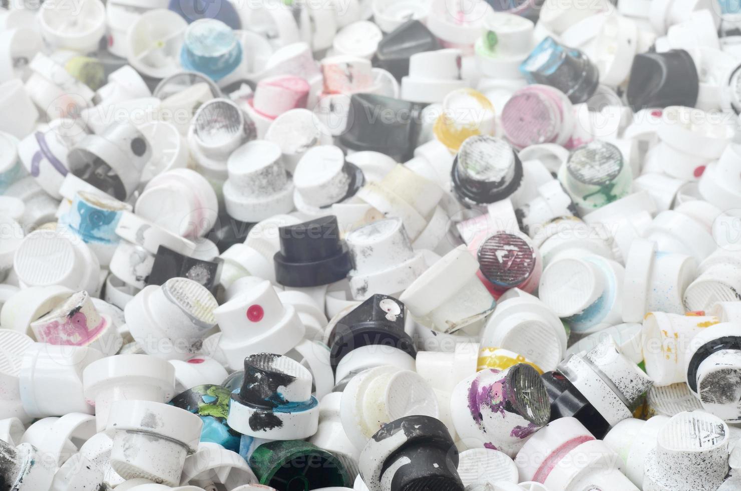 A pattern of many used and soiled nozzles from spray cans with aerosol paint. Background texture of the street art of drawing graffiti on the walls photo