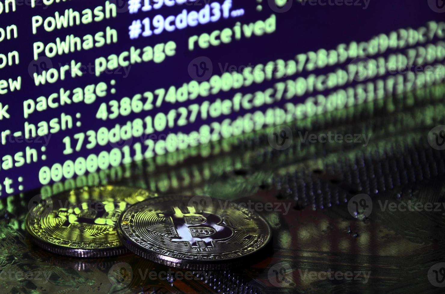 The digital process of cryptocurrency mining by using the GPUs. Bitcoins and video card on a working display and mining screen photo
