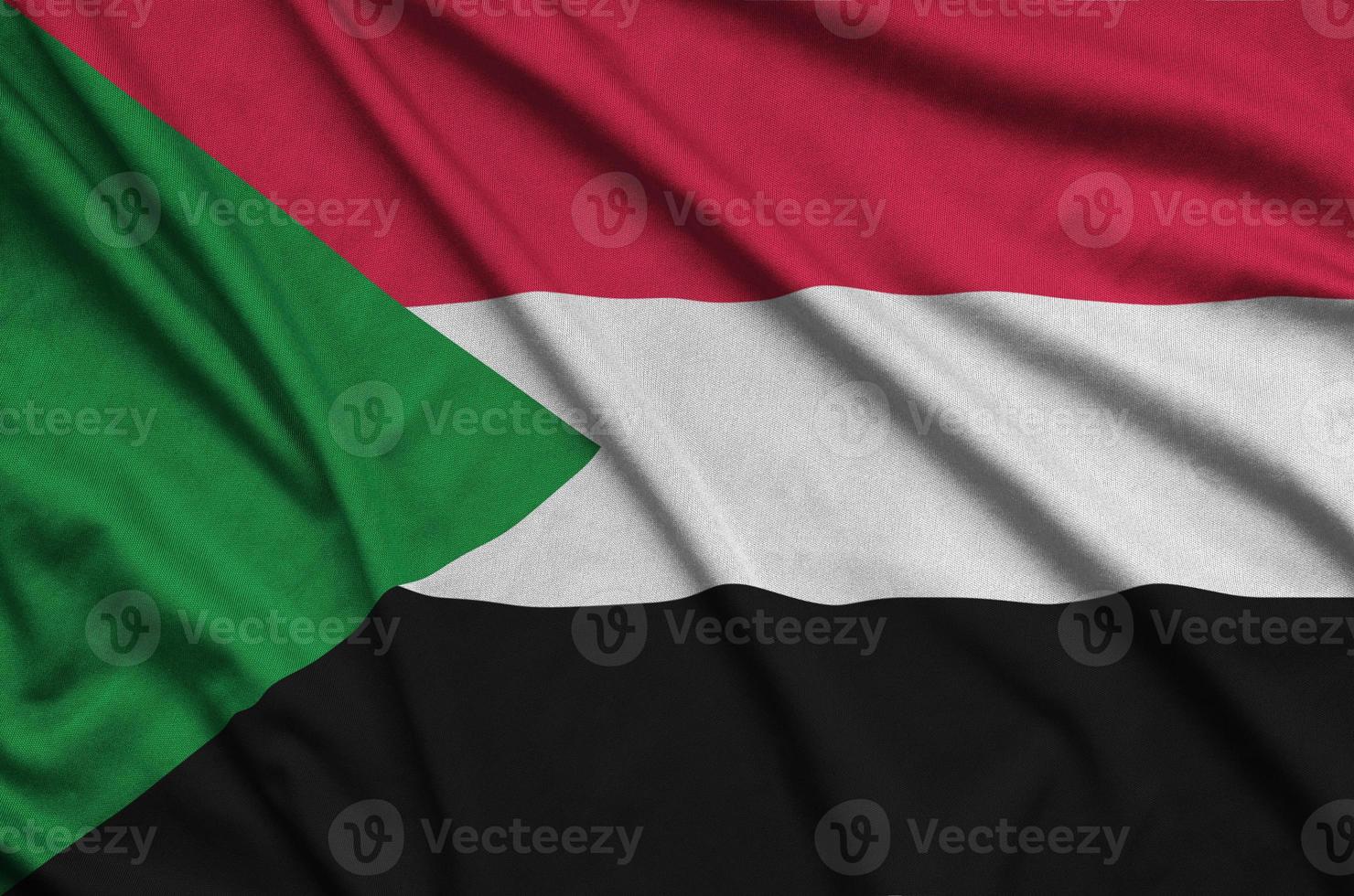 Sudan flag is depicted on a sports cloth fabric with many folds. Sport team banner photo