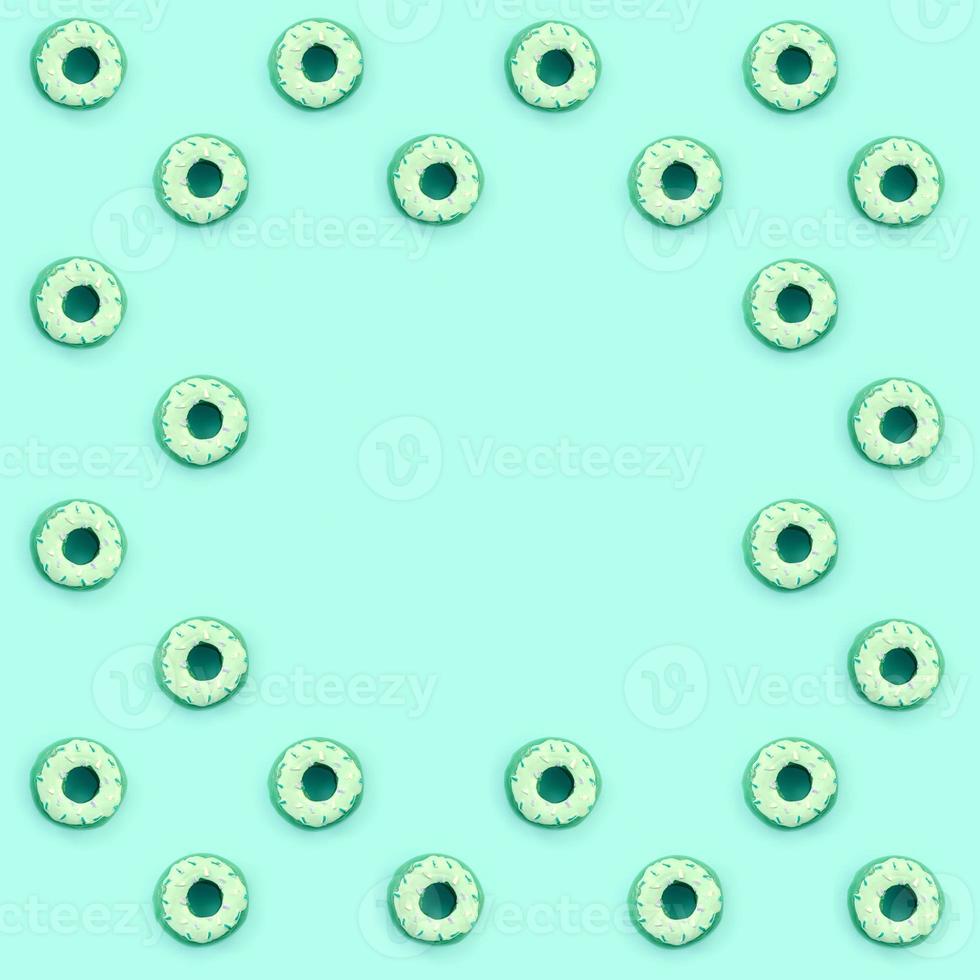 Many small plastic donuts lies on a pastel colorful background. Flat lay minimal pattern. Top view photo