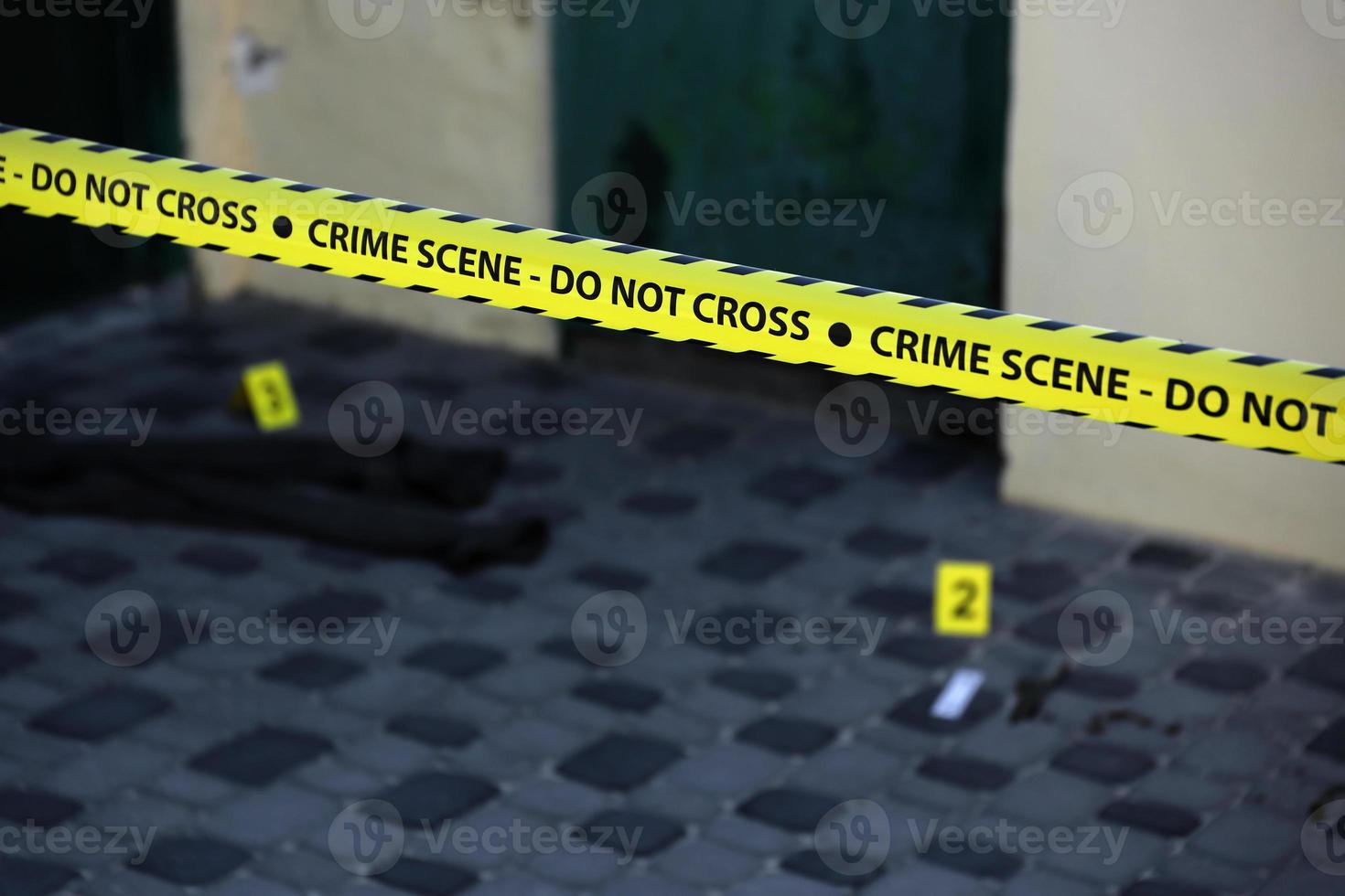 Crime scene tape for covering the area cordon. Yellow tape with blurred forensic law enforcement background in cinematic tone photo