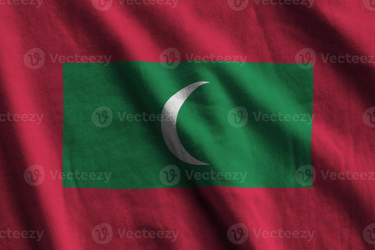Maldives flag with big folds waving close up under the studio light indoors. The official symbols and colors in banner photo