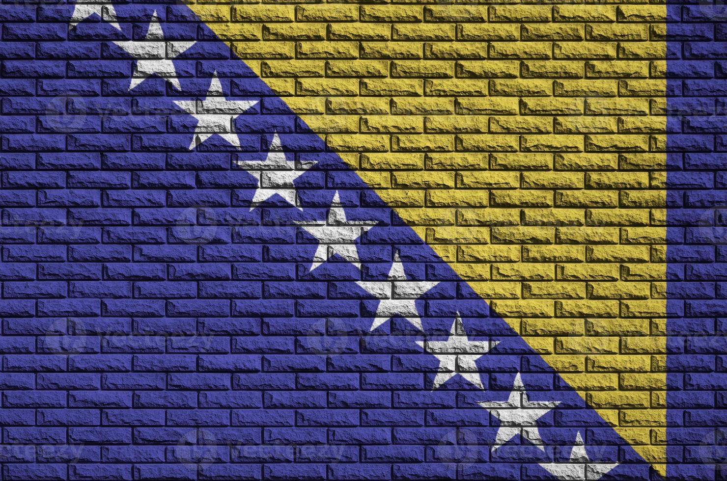 Bosnia and Herzegovina flag is painted onto an old brick wall photo