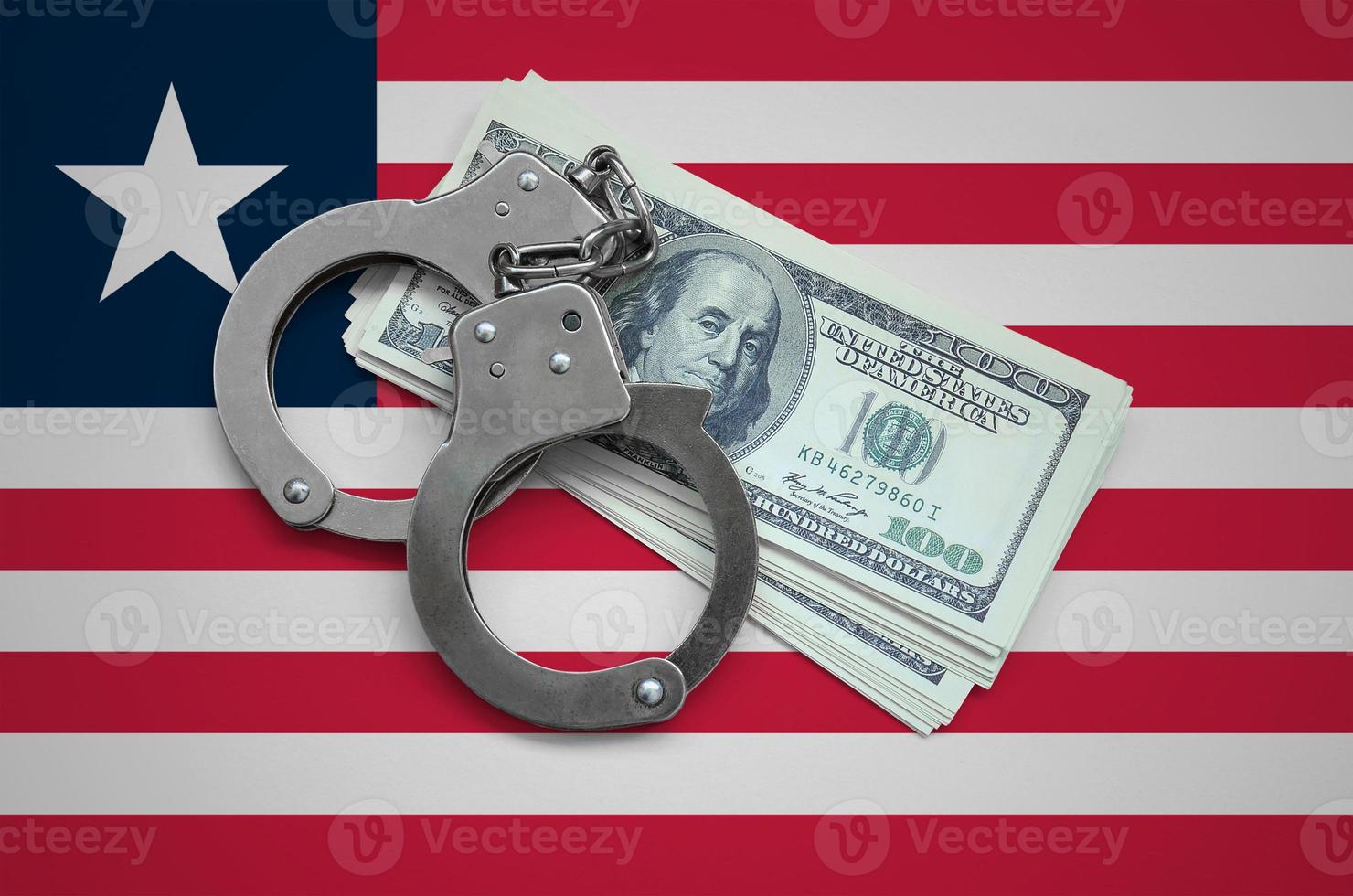 Liberia flag with handcuffs and a bundle of dollars. Currency corruption in the country. Financial crimes photo