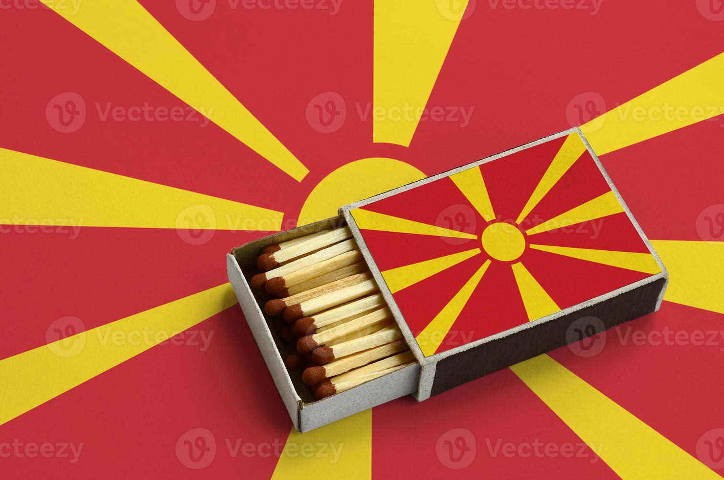 Macedonia flag is shown in an open matchbox, which is filled with matches and lies on a large flag photo