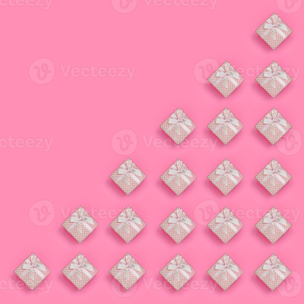 A lot of pink gift boxes lies on texture background of fashion pastel pink color paper in minimal concept. Abstract trendy pattern photo