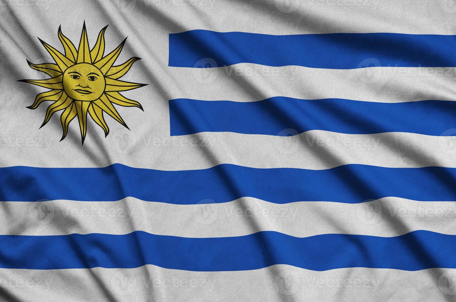 Uruguay flag is depicted on a sports cloth fabric with many folds. Sport team banner photo