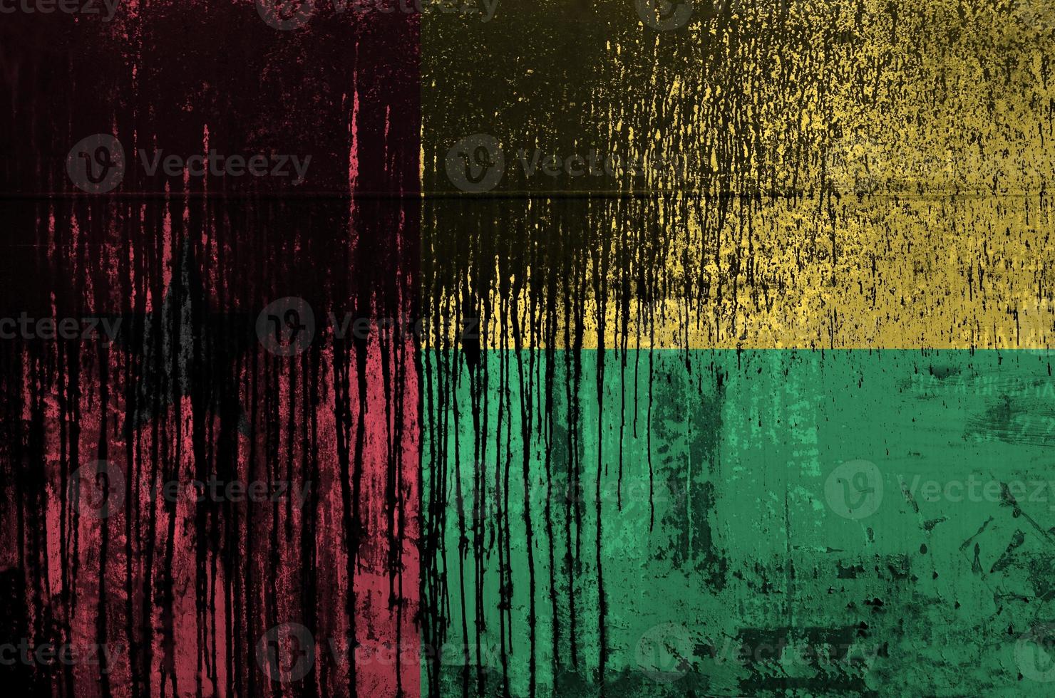 Guinea Bissau flag depicted in paint colors on old and dirty oil barrel wall closeup. Textured banner on rough background photo