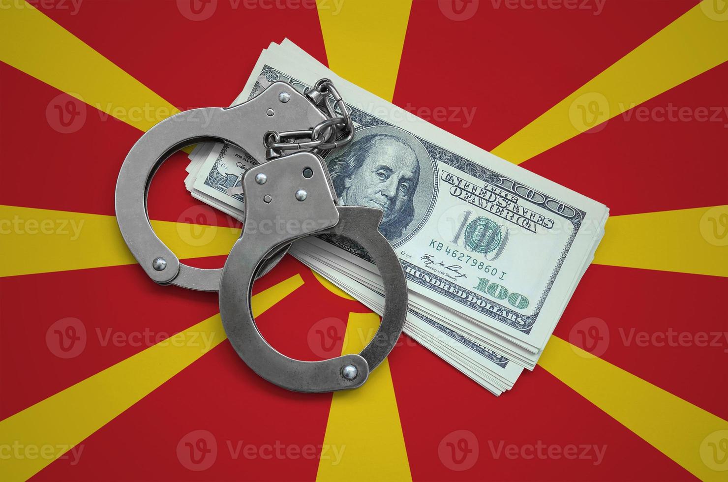 Macedonia flag with handcuffs and a bundle of dollars. Currency corruption in the country. Financial crimes photo
