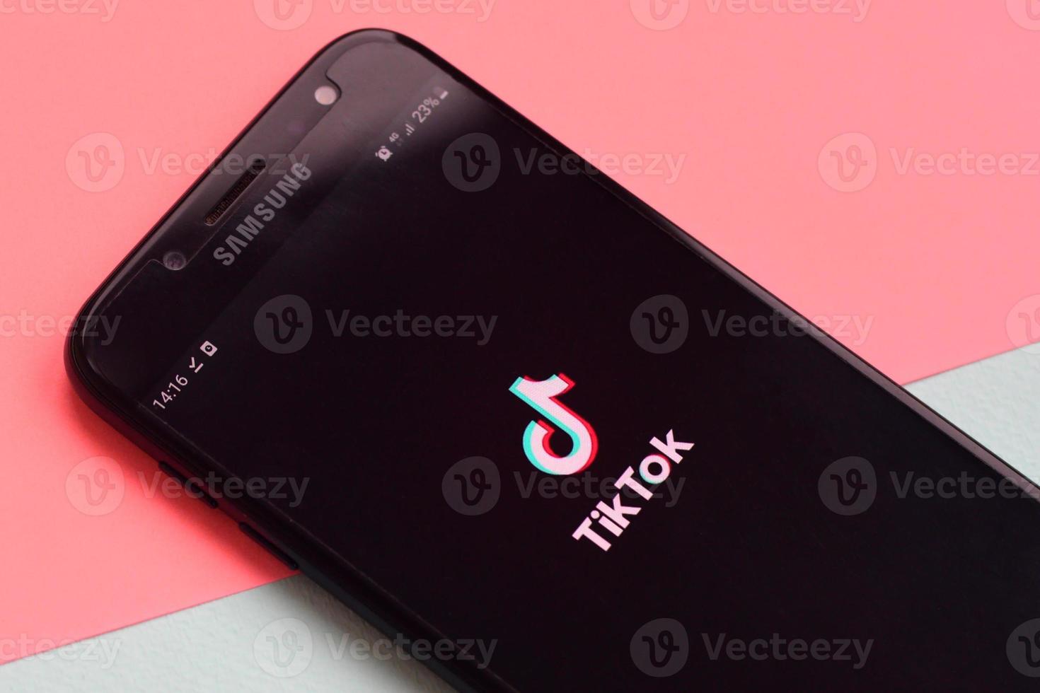 Tiktok application on samsung smartphone screen on pastel background. TikTok is a popular video-sharing social networking service owned by ByteDance photo