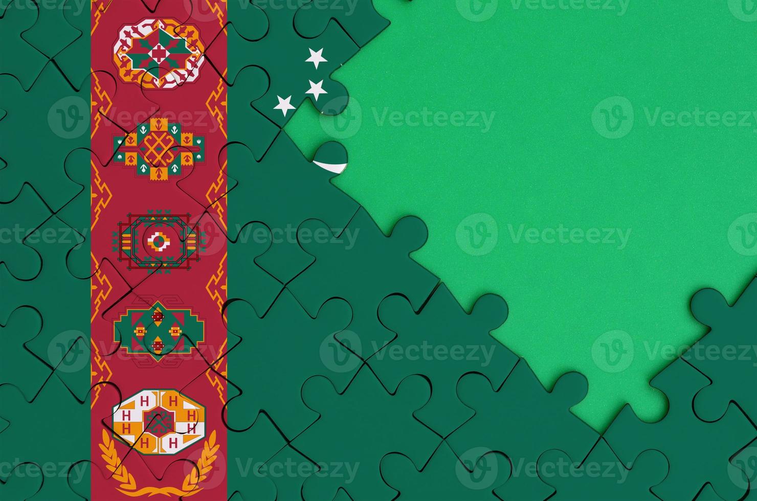 Turkmenistan flag is depicted on a completed jigsaw puzzle with free green copy space on the right side photo