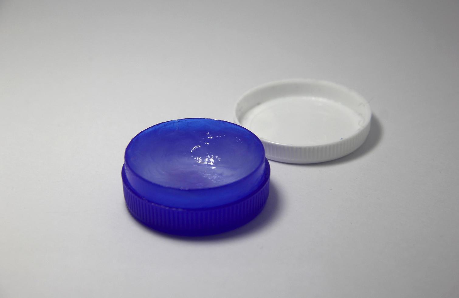 Small opened ointment blue container on simple white background. Can be used for beauty or medical purpose. photo