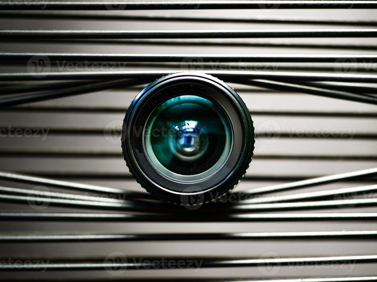 un primer plano de una lente de cámara en tiras de plástico elásticas que crean un ojo foto