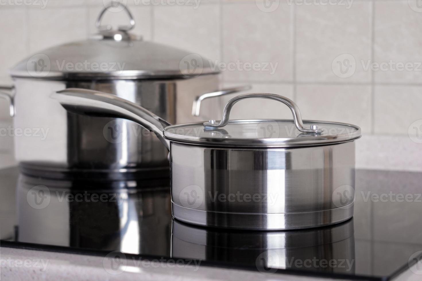 Ladle and large saucepan stand on modern stove with a glass-ceramic hob photo