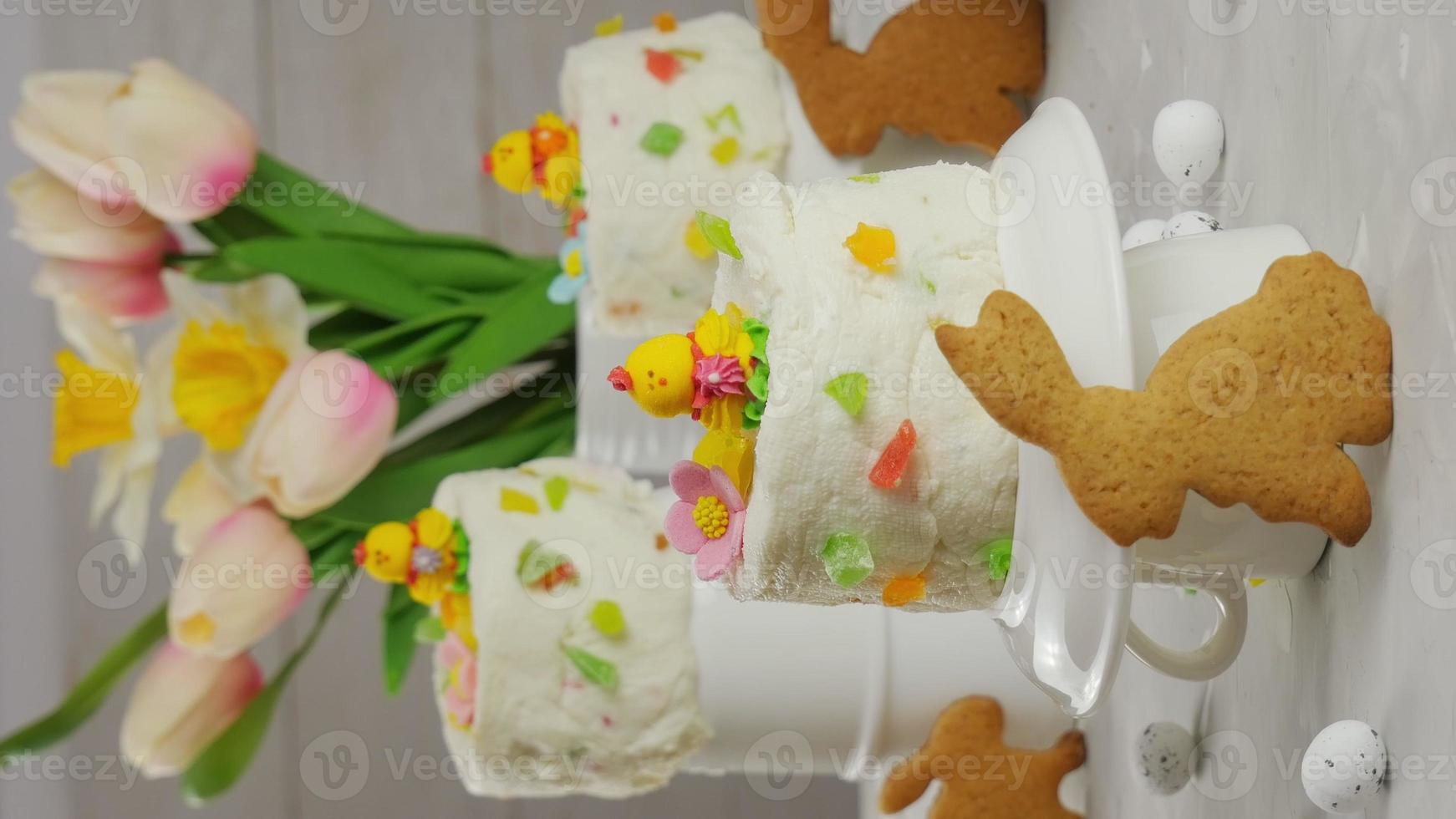 tortas de pascua en la mesa, decoradas con pollos. huevos de Pascua. concepto mínimo. ramo de tulipanes, huevos de pascua. 4k foto