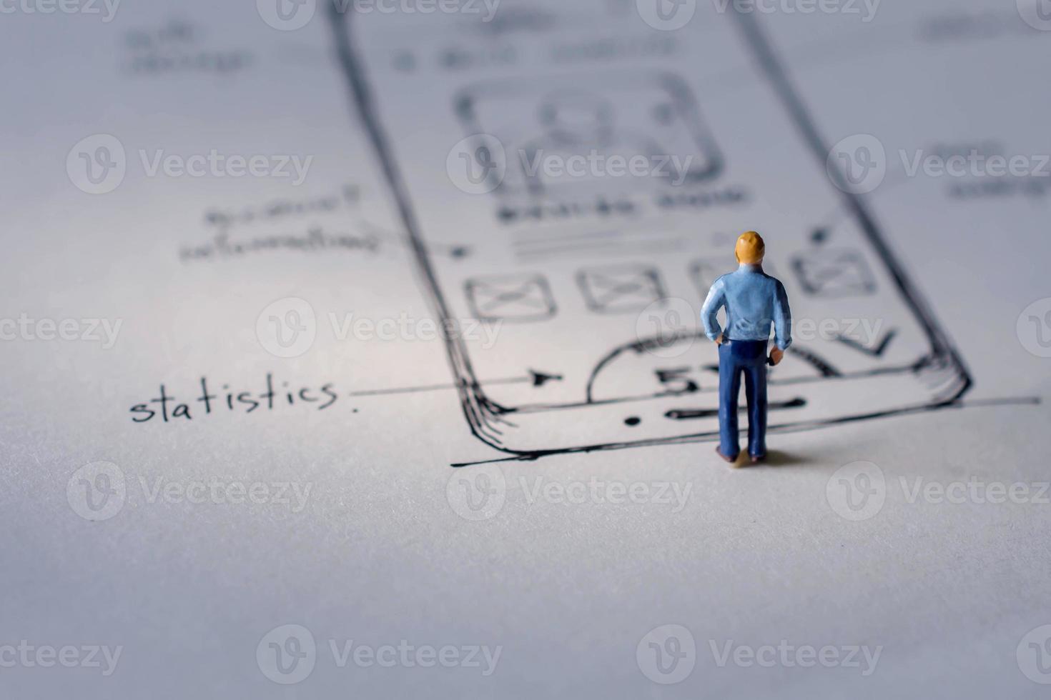 User Experience Concept. present by Miniature Figure of UX UI Designer standing on Paper of Interface Design Sketch photo