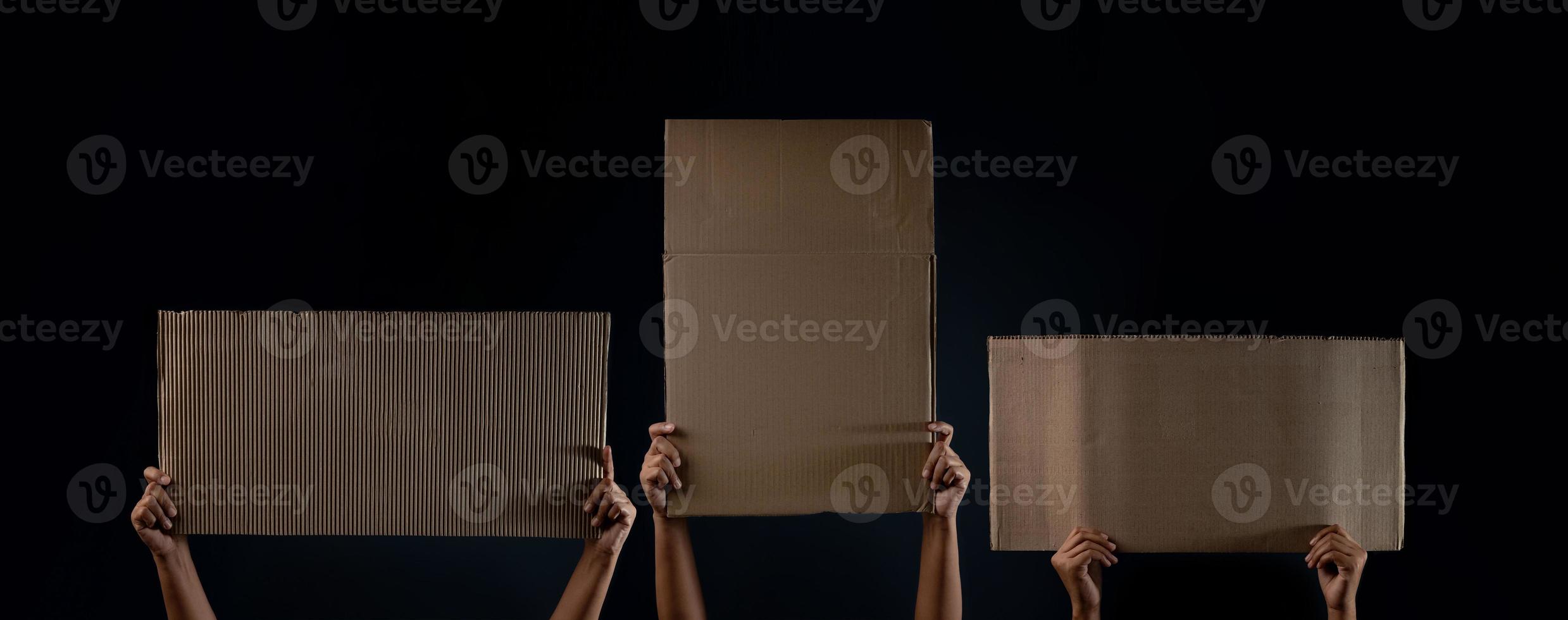 Protest , Mob or Expression Concept. Group of People Raised a Blank Corrugated Paper. Speech Template Texture Background. Front View and Dark tone photo