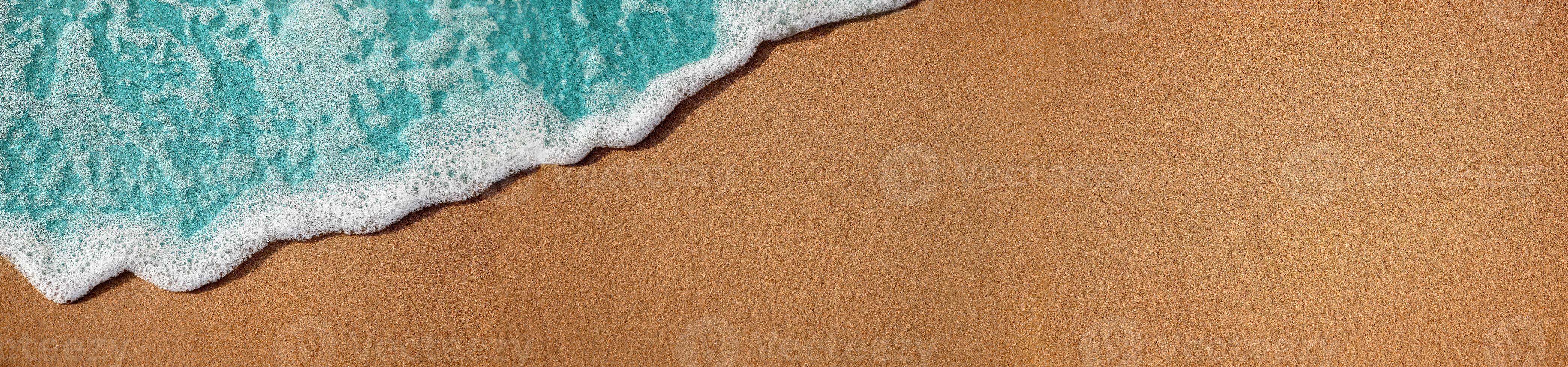 Empty Sand Beach and Soft Blue Wave on Summer Sunny Day. Natural Texture Background. Wide and Long Size for Copy Space. Top View. Focus on Sand photo