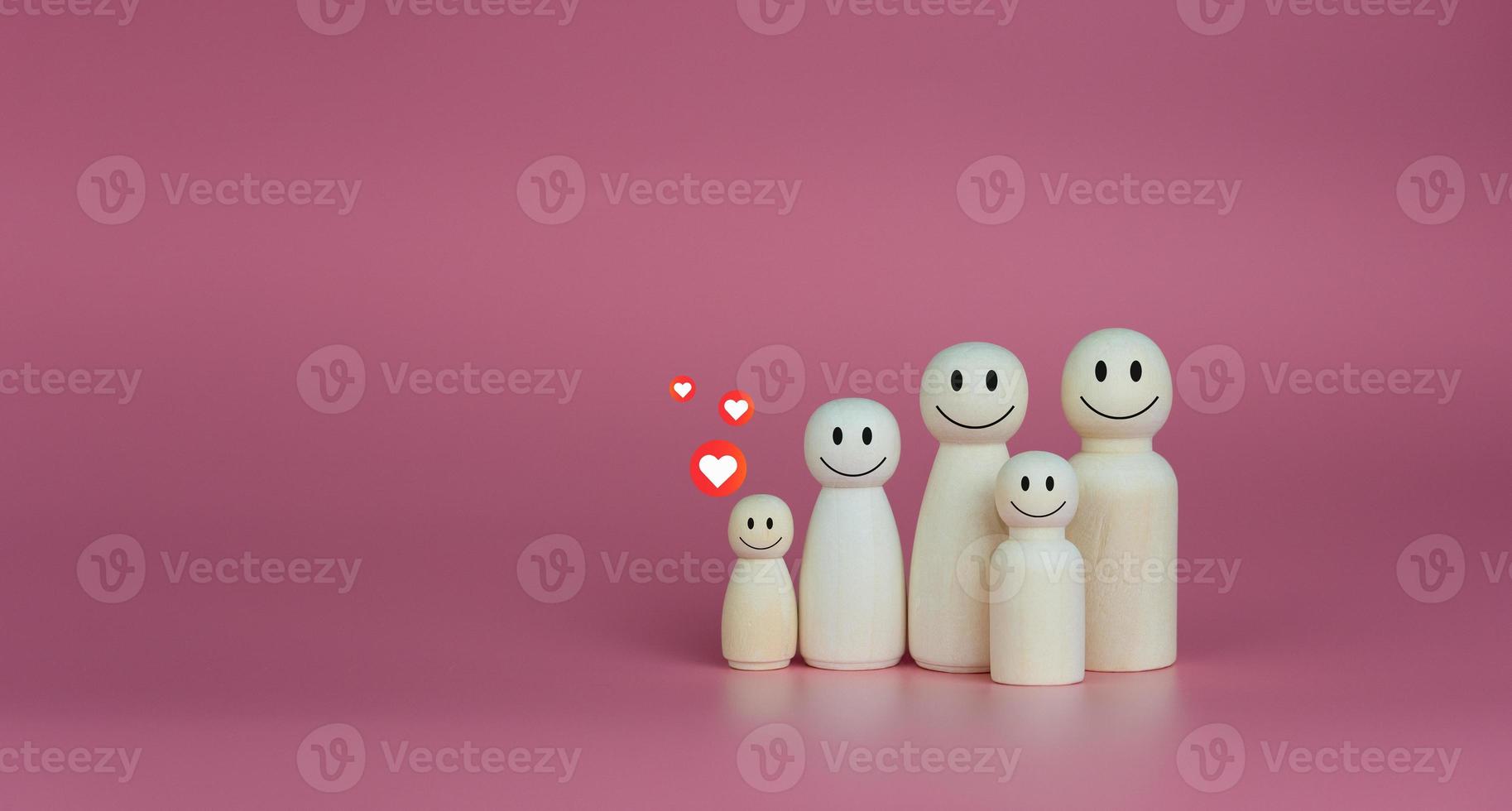 concepto de casa feliz. las muñecas de madera se alinean con iconos de corazón. indica felicidad y amor en el hogar. foto