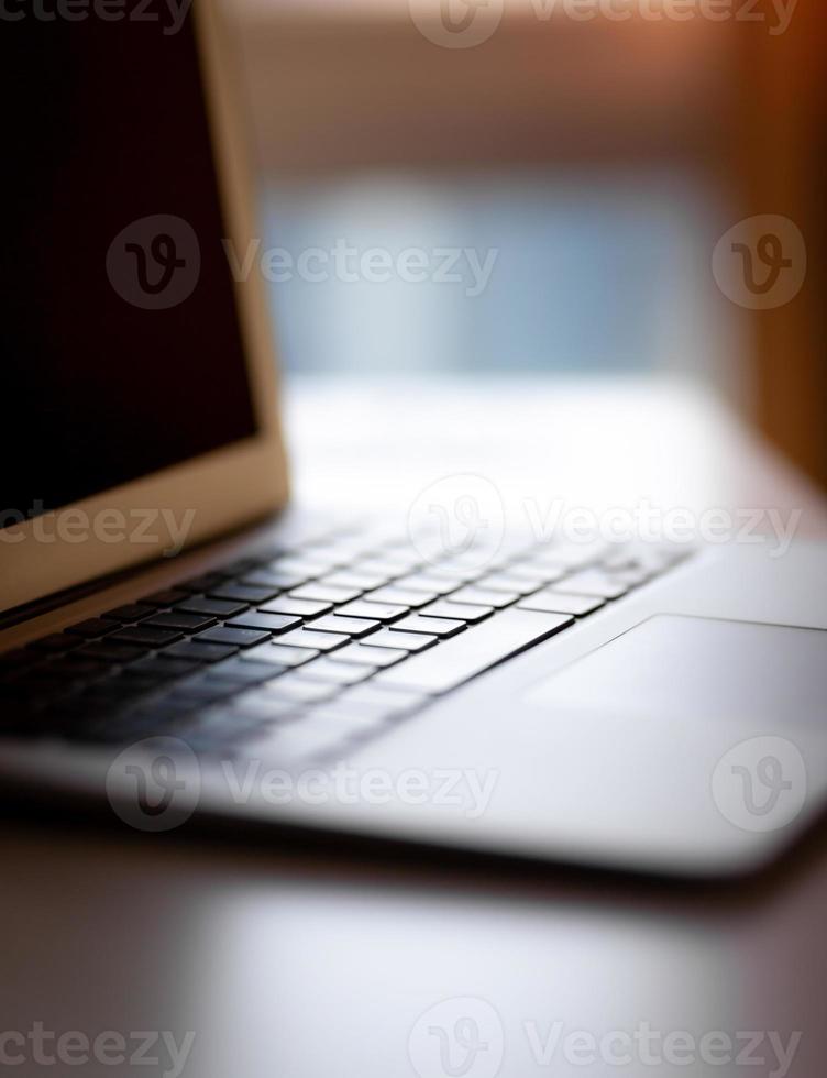 Close-up of the keyboard of an open laptop ready to work on the table. Side view, selective focus on the keyboard. The concept of computer security and work on the Internet. photo