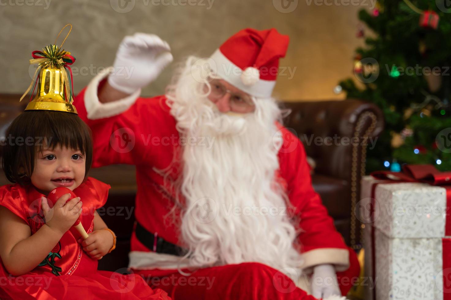 Little kid girl siiting together   with Santa claus on floor.  Celebrate holiday Christmas and Thanksgiving party. photo