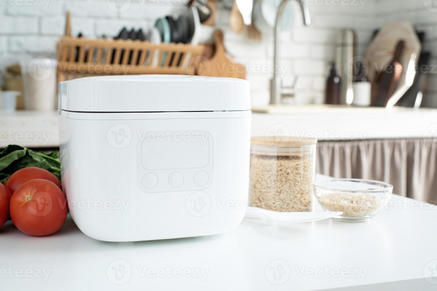 Electric rice cooker on wooden counter-top in the kitchen photo