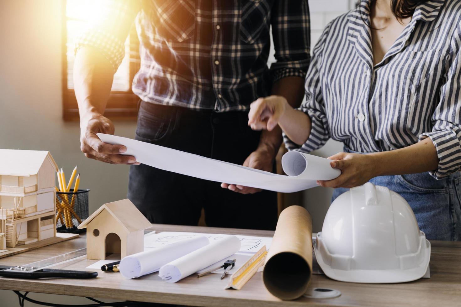 Construction engineer working at blueprint to build large commercial buildings in office. Engineering tools and construction concept. photo