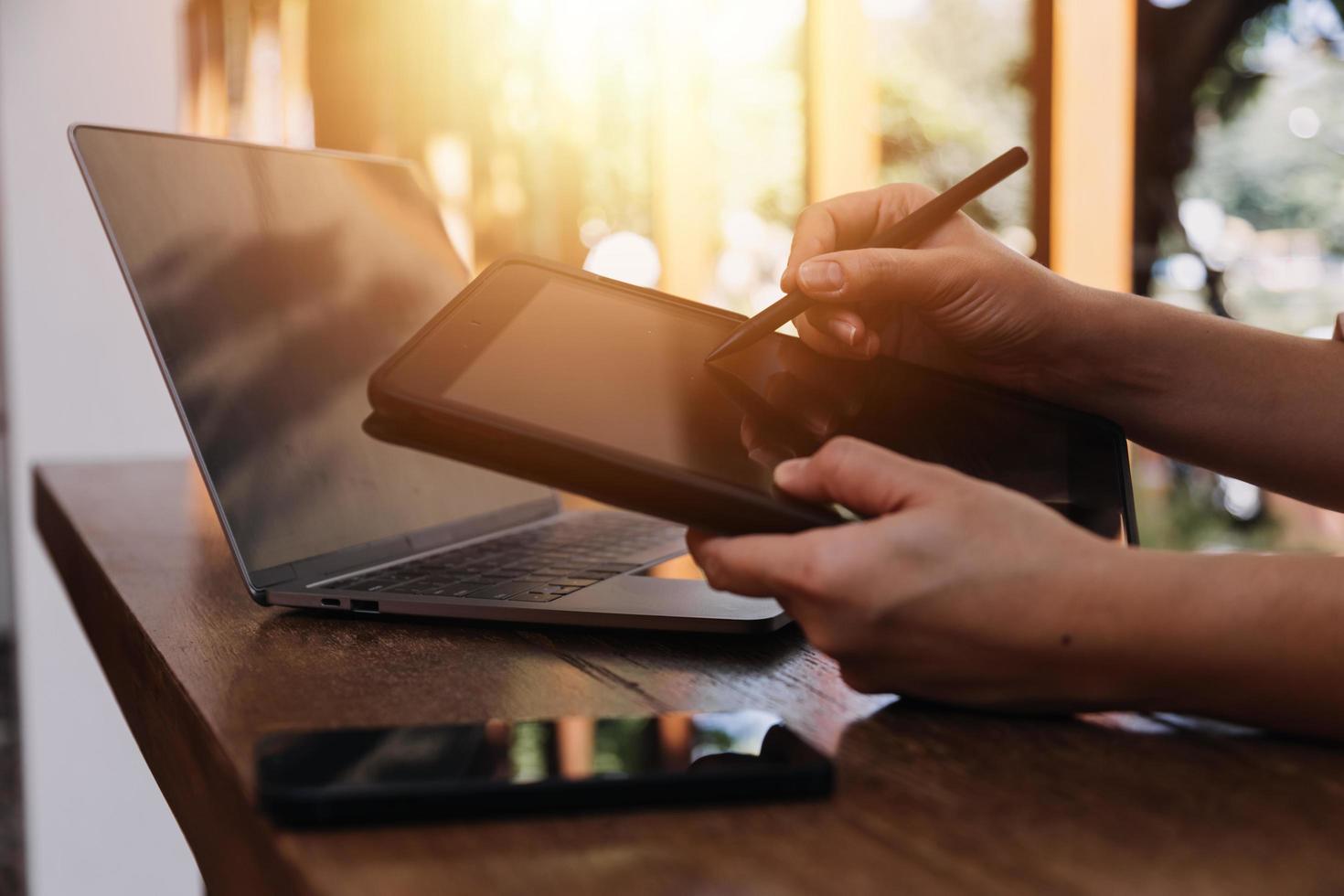 businesswoman hand working with laptop computer, tablet and smart phone in modern office with virtual icon diagram at modernoffice in morning light photo