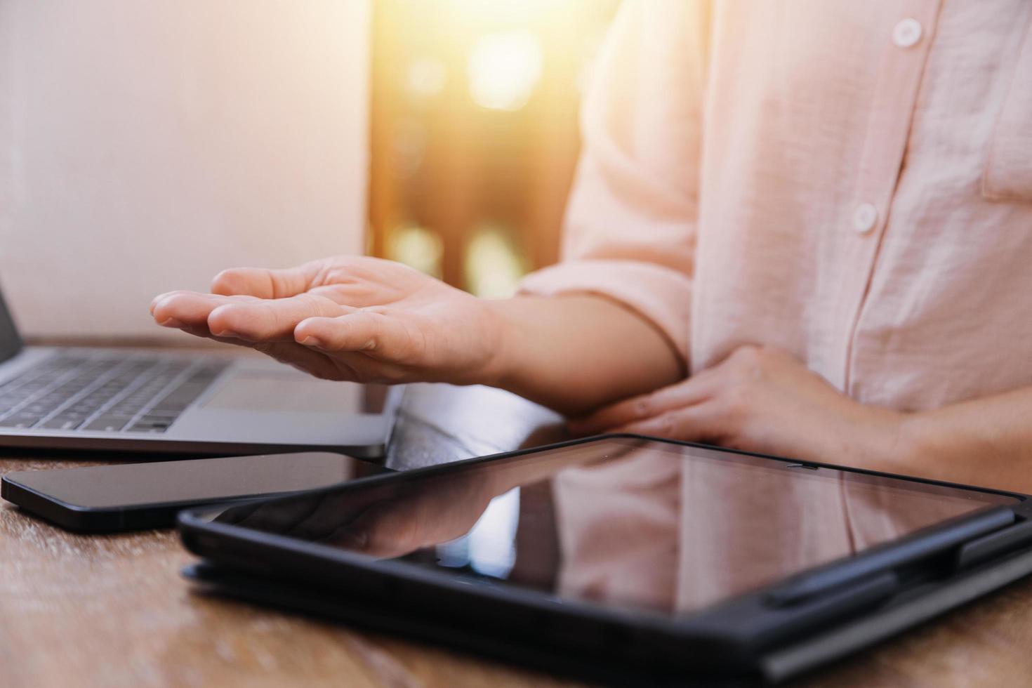 businesswoman hand working with laptop computer, tablet and smart phone in modern office with virtual icon diagram at modernoffice in morning light photo
