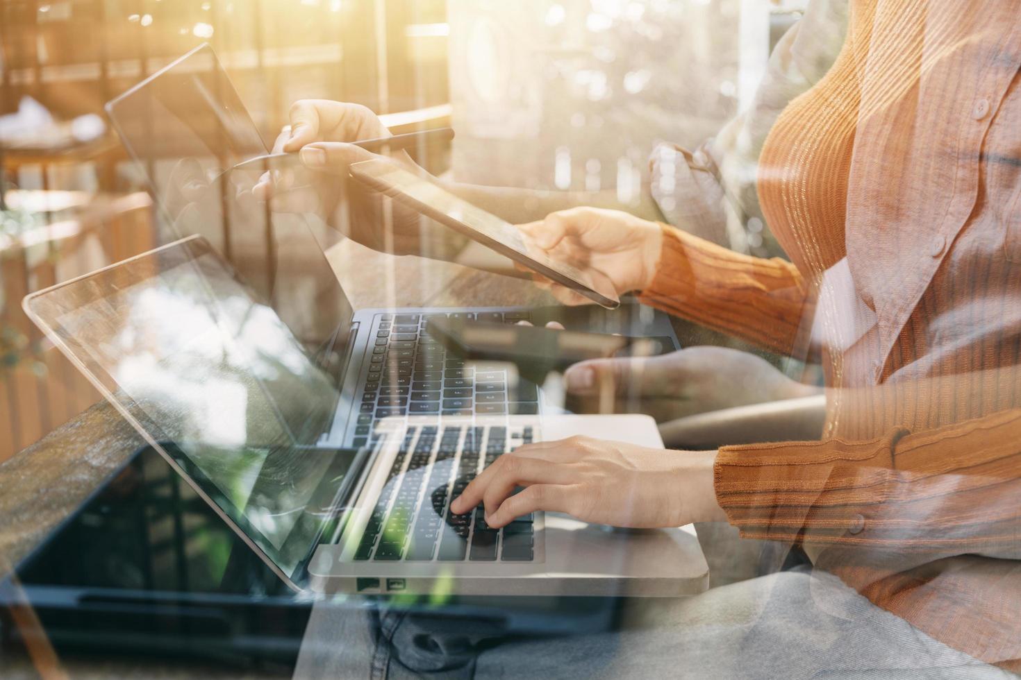 businesswoman hand working with laptop computer, tablet and smart phone in modern office with virtual icon diagram at modernoffice in morning light photo