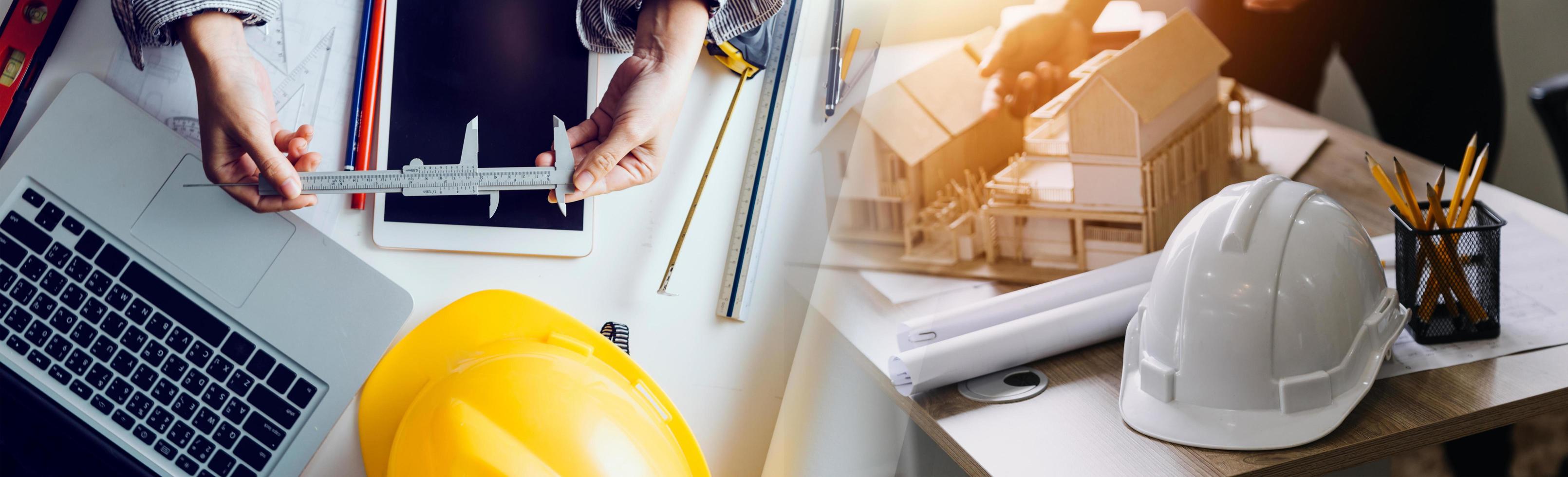 Two colleagues discussing data working and tablet, laptop with on on architectural project at construction site at desk in office photo