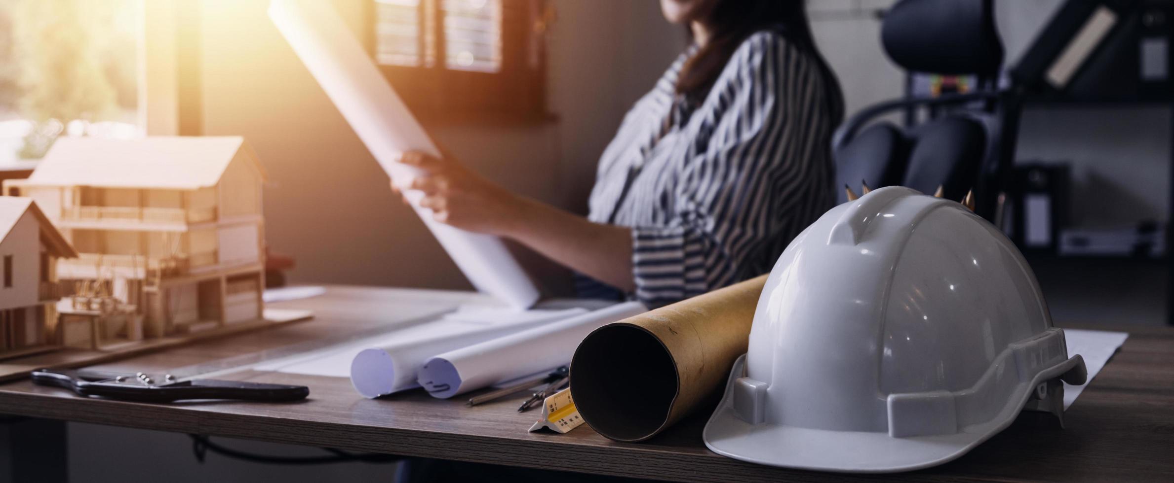 Construction engineer working at blueprint to build large commercial buildings in office. Engineering tools and construction concept. photo