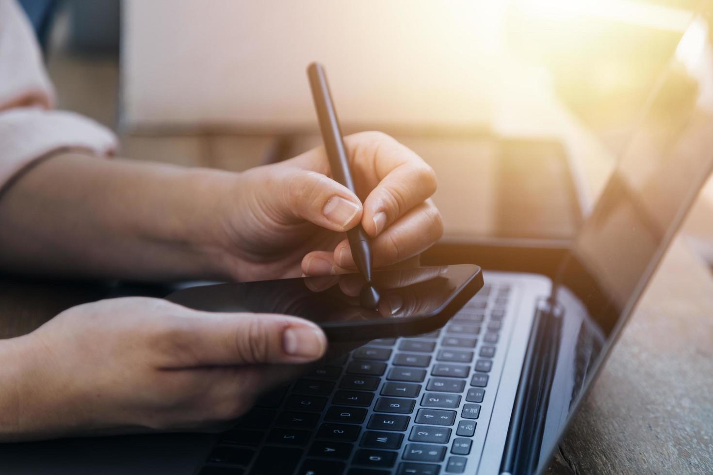 businesswoman hand working with laptop computer, tablet and smart phone in modern office with virtual icon diagram at modernoffice in morning light photo