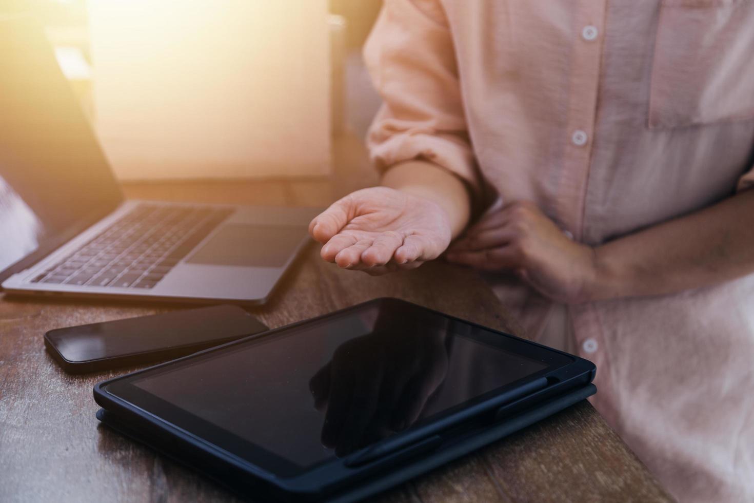 businesswoman hand working with laptop computer, tablet and smart phone in modern office with virtual icon diagram at modernoffice in morning light photo
