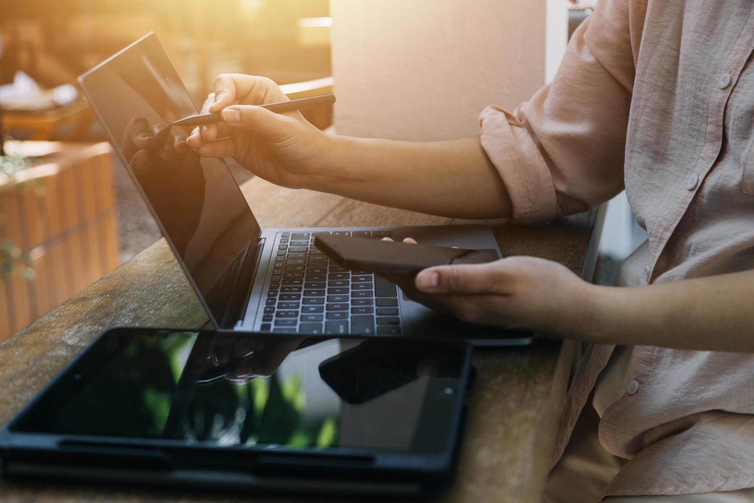 businesswoman hand working with laptop computer, tablet and smart phone in modern office with virtual icon diagram at modernoffice in morning light photo