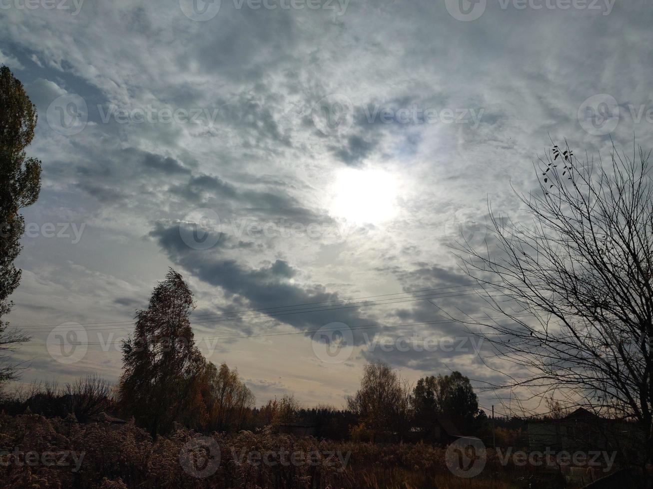 Multi-colored clouds fly over the village photo