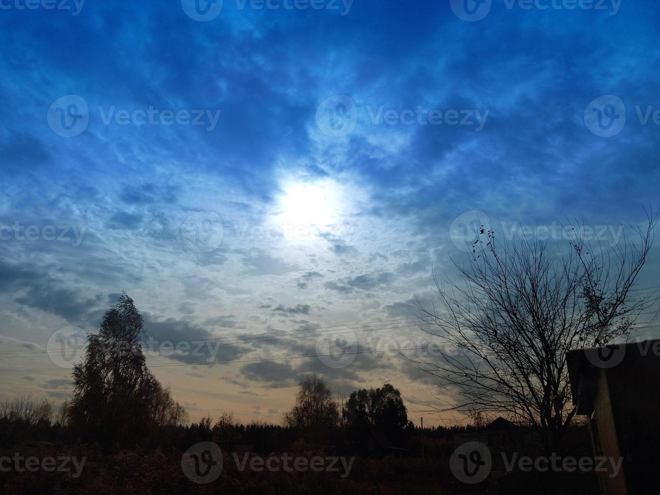 Multi-colored clouds fly over the village photo