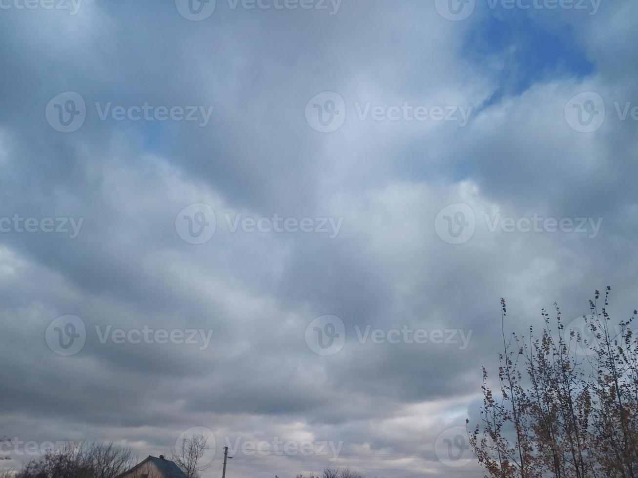 Multi-colored clouds fly over the village photo