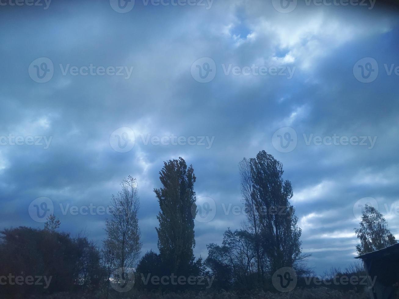 Multi-colored clouds fly over the village photo