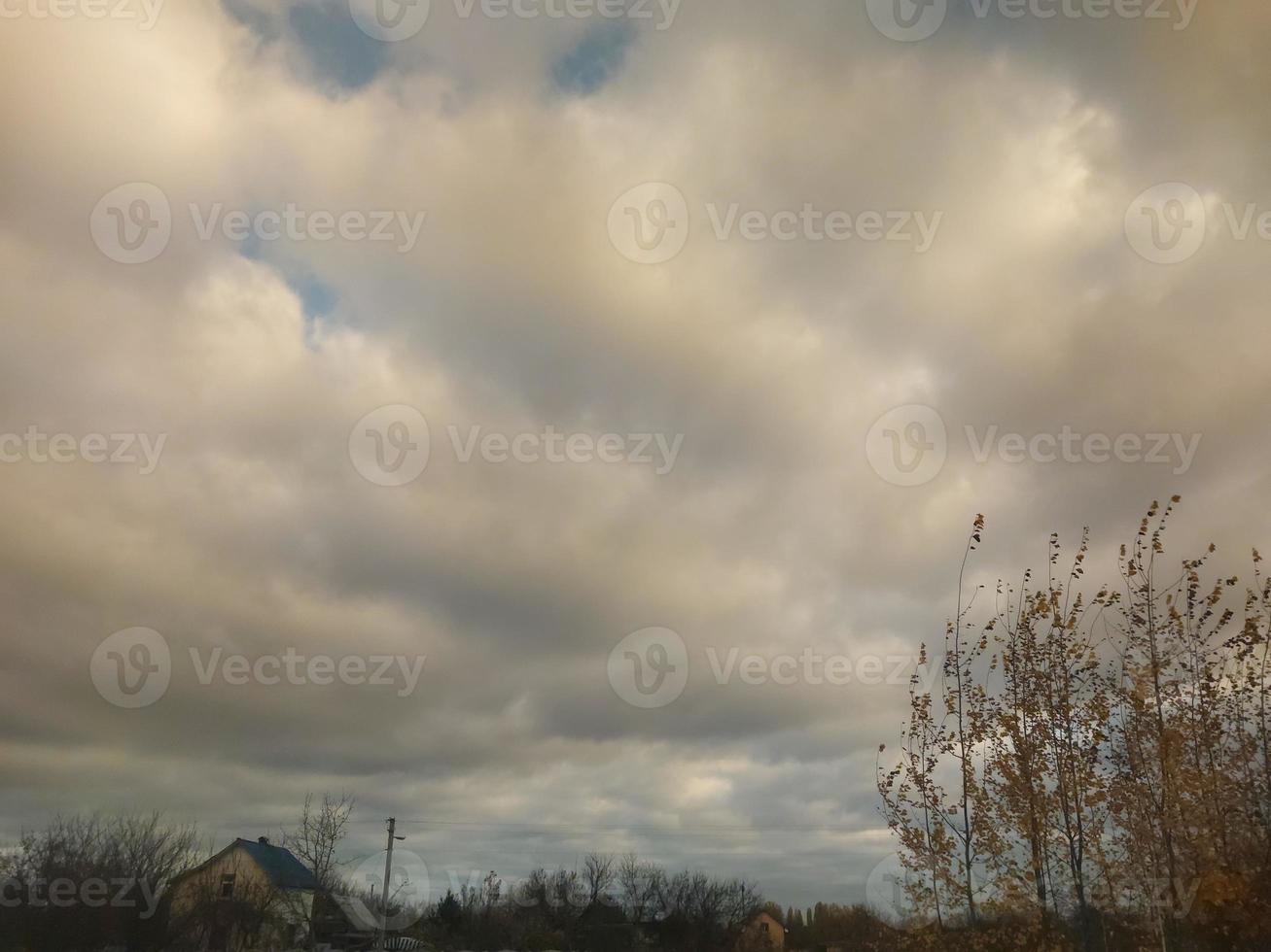 Multi-colored clouds fly over the village photo