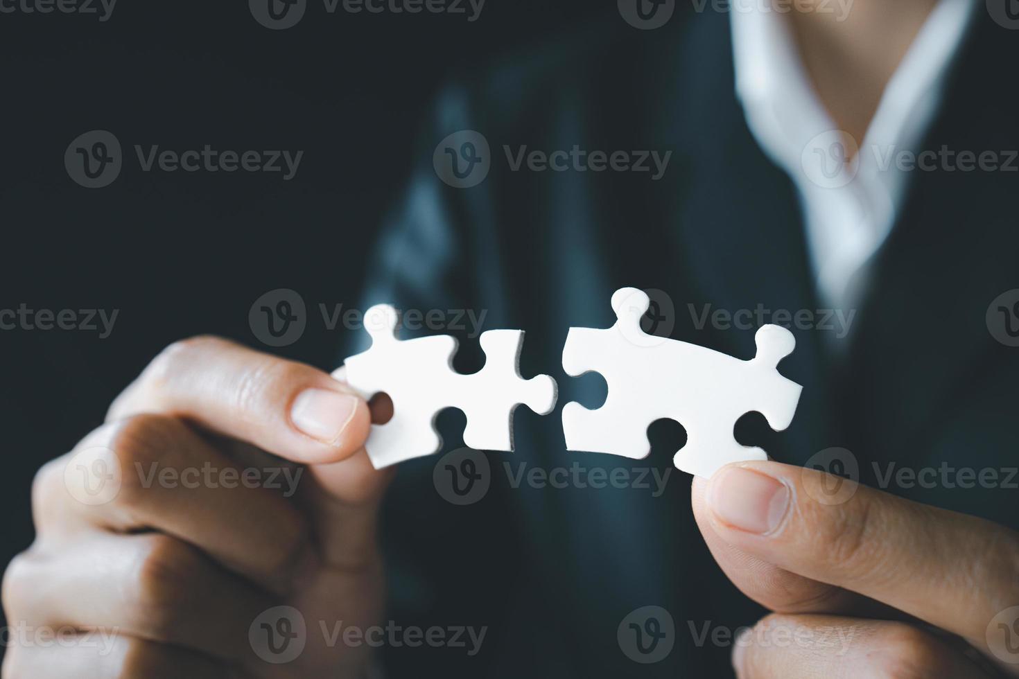 Business woman is trying to connect couple puzzle piece. Symbol of association and connection. Concept of business strategy photo