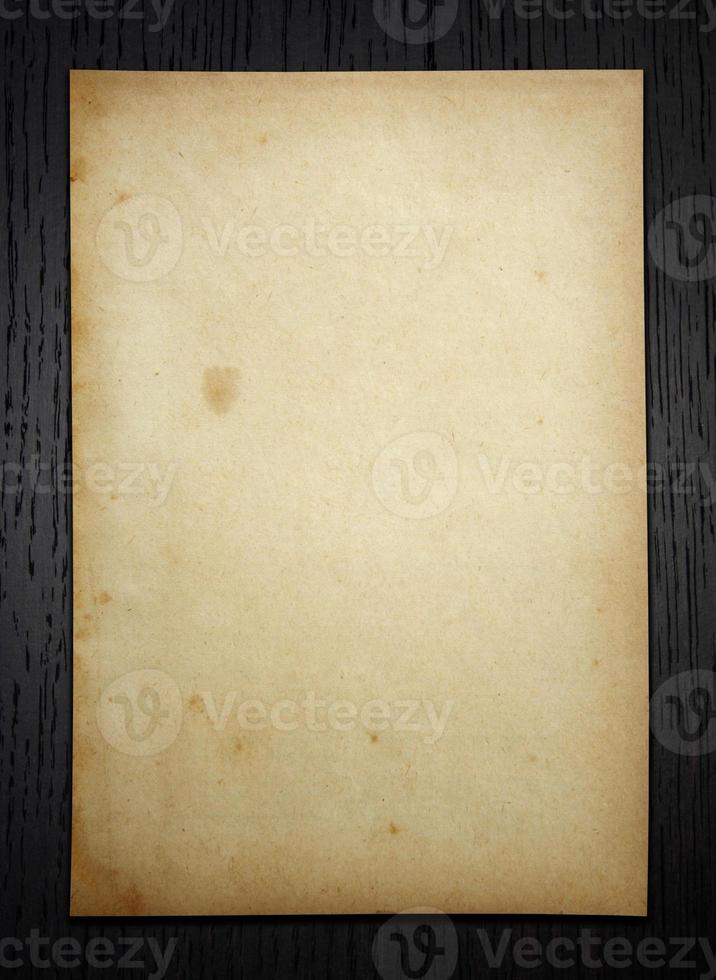 Old paper on dark wood  background with clipping path photo