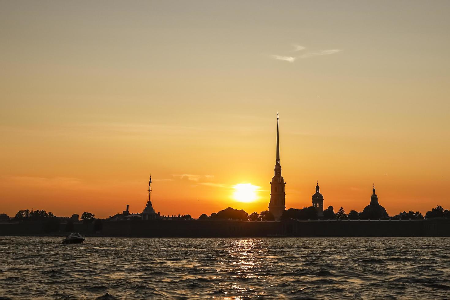 the silhouette of the Peter and Paul Fortress at sunset, view from the Neva River photo