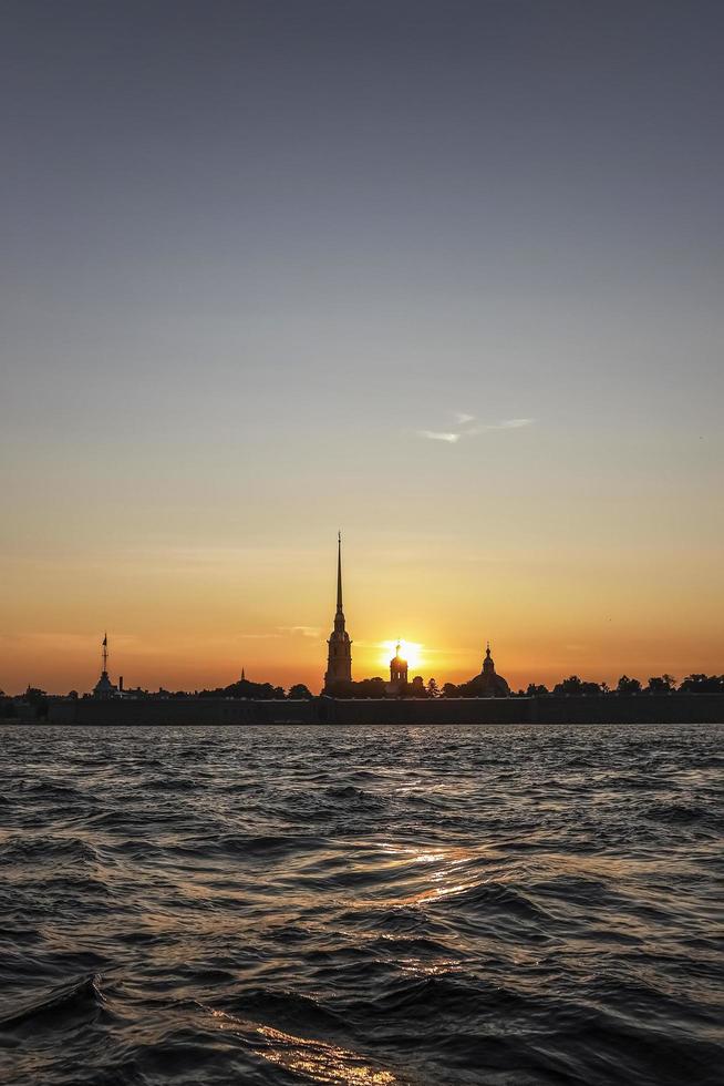 the silhouette of the Peter and Paul Fortress at sunset, view from the Neva River photo