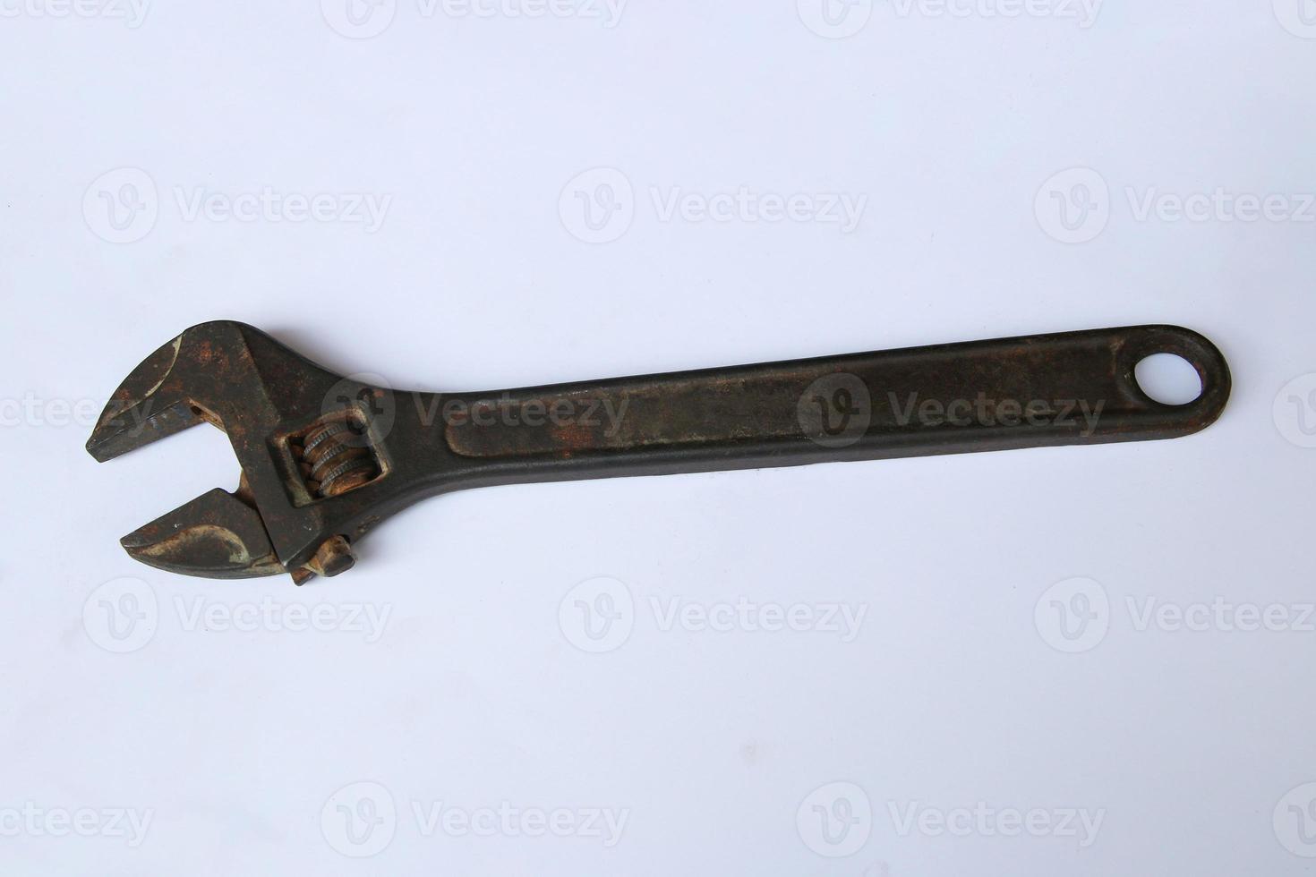 Old rusty adjustable wrench on white background. Old rusty iron wrench with clipping path. Top-view photo
