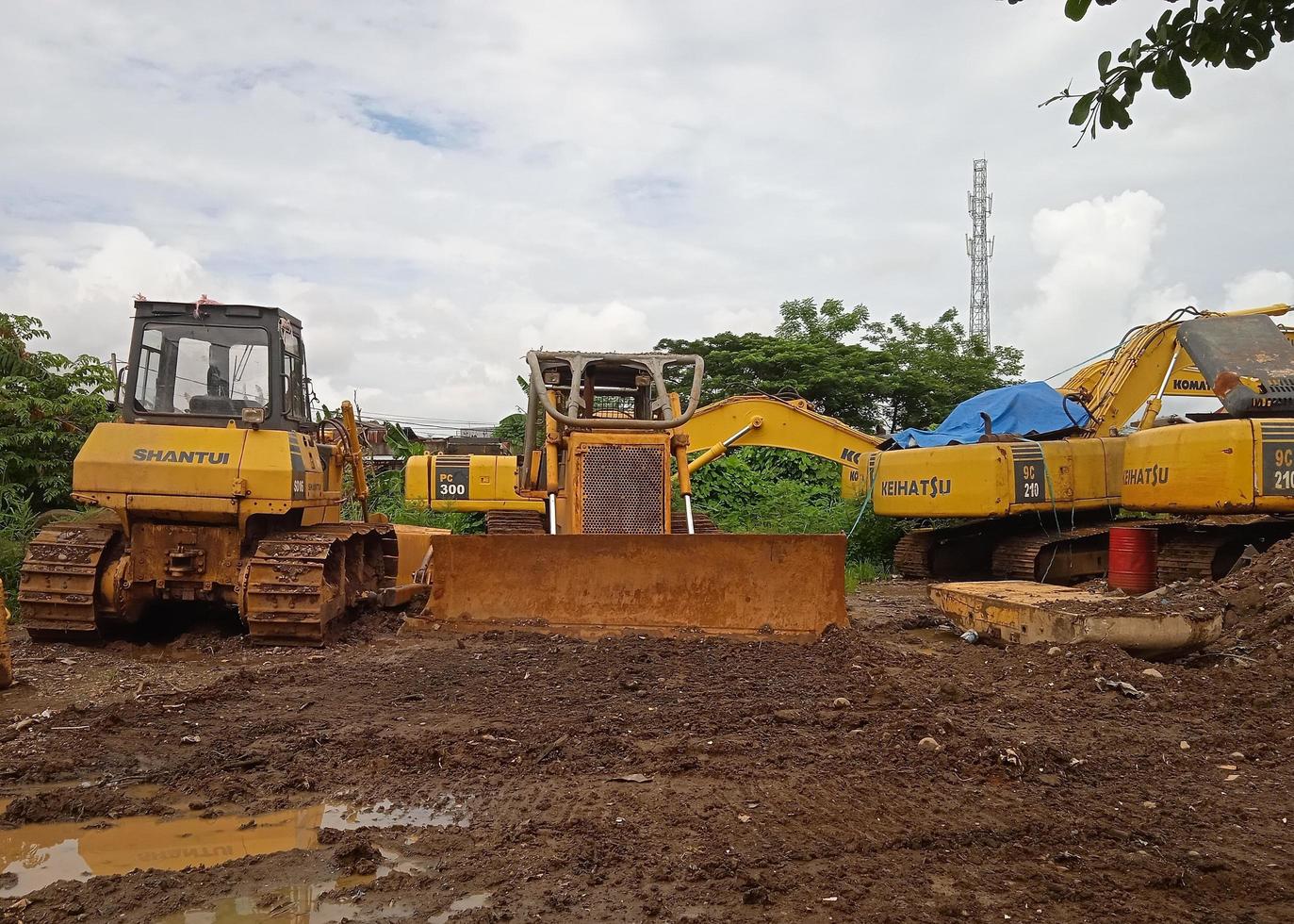 Morowali, Indonesia, 10 may 2022- bulldozer and excavator operating at a mine site against a white cloud background photo